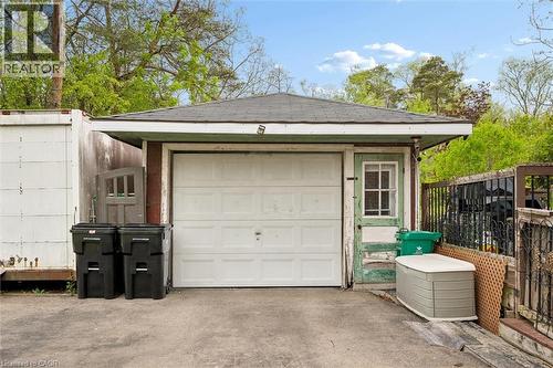 Detached garage structure featuring a white panel garage door, a side entry door with a multi-pane window, and a dark shingled roof - 786 S Stirling Avenue S, Kitchener, ON - Outdoor With Exterior