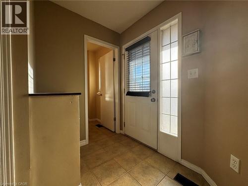 Entryway featuring tile flooring, a white door with an integrated window blind, and an adjacent sidelight window - 37 Northcliffe Crescent, Cambridge, ON - Indoor Photo Showing Other Room
