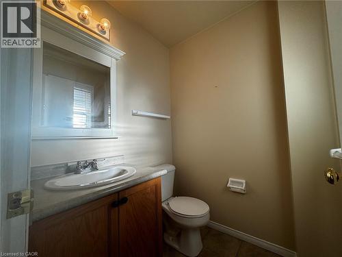 Bathroom vanity featuring a wood-finish cabinet, integrated sink, and chrome faucet - 37 Northcliffe Crescent, Cambridge, ON - Indoor Photo Showing Bathroom