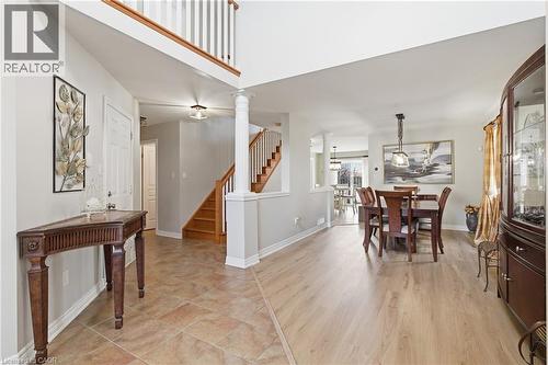 Foyer entry featuring a two-story ceiling, a staircase with wood treads and white risers, and a prominent column - 84 Duncairn Crescent, Hamilton, ON - Indoor Photo Showing Dining Room