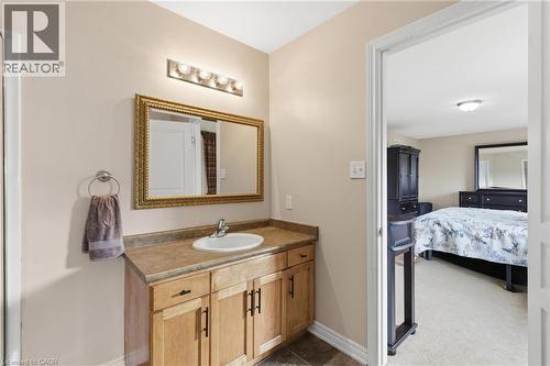 Bathroom vanity featuring a light wood-finish cabinet with dark hardware, an integrated sink, and a countertop - 84 Duncairn Crescent, Hamilton, ON - Indoor Photo Showing Bathroom