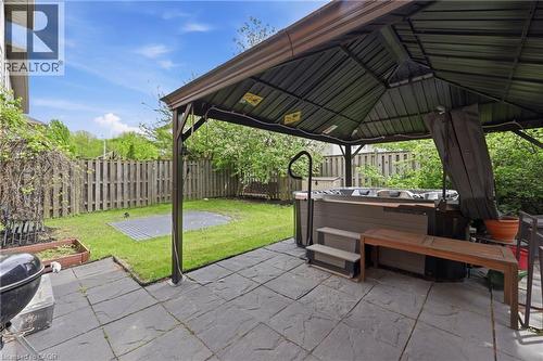 Private backyard featuring a hot tub beneath a freestanding gazebo, complemented by a stone paver patio - 84 Duncairn Crescent, Hamilton, ON - Outdoor