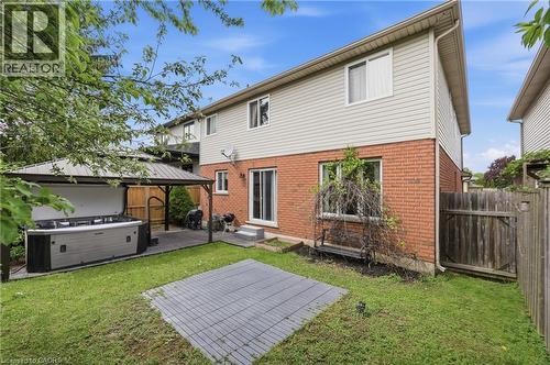 Backyard featuring a covered hot tub, a manicured lawn, and a privacy fence - 84 Duncairn Crescent, Hamilton, ON - Outdoor With Exterior