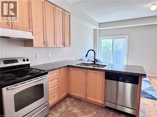 Kitchen featuring light wood cabinetry, stainless steel appliances, dark speckled countertops, and tile flooring - 110 Highland Road E Unit# 53, Kitchener, ON - Indoor Photo Showing Kitchen With Double Sink