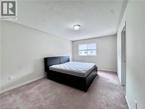 Bedroom featuring neutral-toned carpeting, white painted walls, a standard window, and an overhead flush-mount light fixture - 110 Highland Road E Unit# 53, Kitchener, ON - Indoor Photo Showing Bedroom