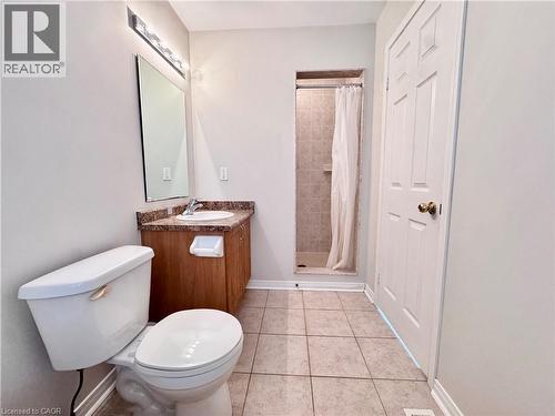 Bathroom featuring a vanity with a countertop sink, an overhead light fixture, a tiled shower, and ceramic tile flooring - 110 Highland Road E Unit# 53, Kitchener, ON - Indoor Photo Showing Bathroom