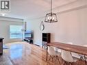 Spacious interior featuring wood-finish flooring, a contemporary black metal framed chandelier, a large window with horizontal blinds, and smooth light-toned walls - 110 Highland Road E Unit# 53, Kitchener, ON  - Indoor Photo Showing Dining Room 