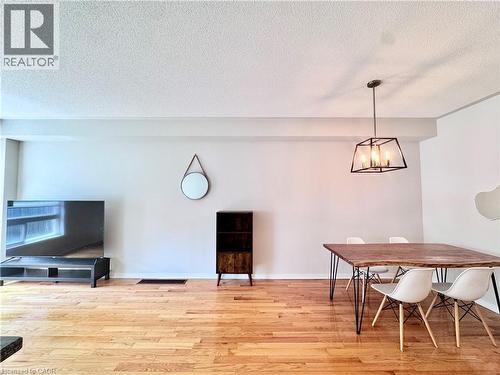 Open concept living and dining area featuring wood-finish flooring, recessed lighting, and a modern geometric pendant light fixture - 110 Highland Road E Unit# 53, Kitchener, ON - Indoor Photo Showing Dining Room