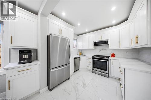 Kitchen featuring stainless steel appliances, light marble finish floors, white cabinetry, light stone countertops, and recessed lighting - 273 Stinson Crescent, Hamilton, ON - Indoor Photo Showing Kitchen