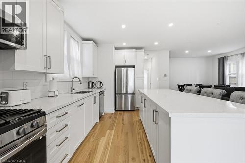 Kitchen featuring stainless steel appliances, white cabinets, a center island, light wood-type flooring, and recessed lighting - 129 Jackson Street W, Hamilton, ON - Indoor Photo Showing Kitchen With Stainless Steel Kitchen With Upgraded Kitchen