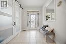 Foyer featuring tile flooring, a decorative glass entry door with sidelights, a transom window, and white barn-style sliding closet doors with frosted panels and black hardware - 58 Doon Creek Street, Kitchener, ON  - Indoor Photo Showing Other Room 