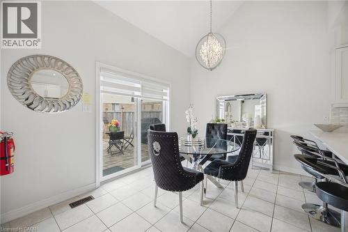 Dining area featuring vaulted ceilings, a contemporary chandelier, and tile flooring - 58 Doon Creek Street, Kitchener, ON - Indoor Photo Showing Dining Room