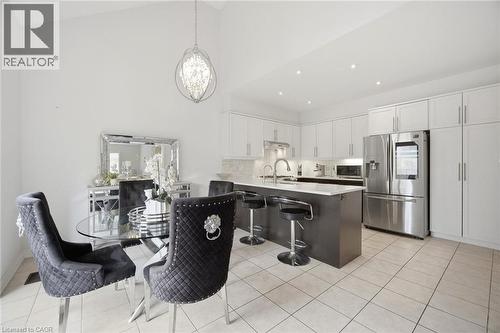 Open-concept kitchen and dining area featuring a vaulted ceiling and an ornate chandelier - 58 Doon Creek Street, Kitchener, ON - Indoor