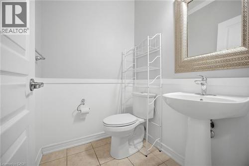 Pedestal sink with chrome faucet, complemented by a decorative framed mirror - 58 Doon Creek Street, Kitchener, ON - Indoor Photo Showing Bathroom