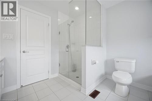 Bathroom featuring a glass-enclosed shower, white tile flooring, and a standard toilet - 58 Doon Creek Street, Kitchener, ON - Indoor Photo Showing Bathroom
