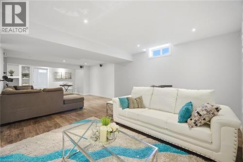 Spacious living area featuring wood-finish flooring, recessed lighting, and a window - 58 Doon Creek Street, Kitchener, ON - Indoor