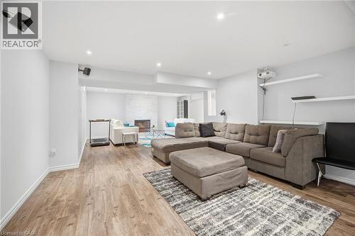 Spacious lower level featuring wood-finish flooring and recessed lighting - 58 Doon Creek Street, Kitchener, ON - Indoor Photo Showing Living Room