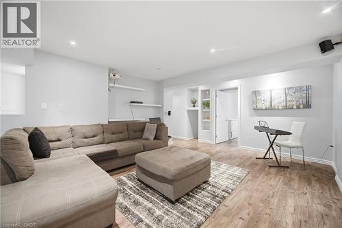 Spacious finished room featuring wood-finish flooring, recessed lighting, and built-in shelving - 58 Doon Creek Street, Kitchener, ON - Indoor Photo Showing Living Room