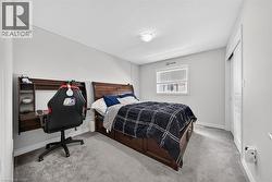 Carpeted room featuring a window with blinds, a built-in wall desk, white trim, and a flush-mount ceiling light fixture - 