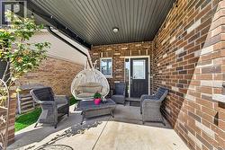Covered patio featuring a concrete surface, brick exterior, and dark soffit - 