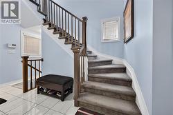 Curved staircase with carpeted treads and wood balusters - 