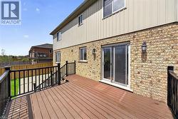 Spacious outdoor deck with composite decking and black metal railings, featuring direct access to the interior via sliding glass doors - 
