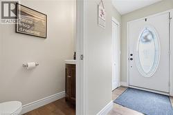 White paneled entry door with an oval-shaped decorative glass insert - 