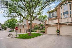 Brick exterior featuring an integrated two-car garage with arched entrances, a bay window, and an upper-level balcony with white railings - 
