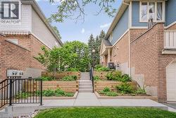 Tiered landscaping featuring wood-finish retaining walls and established greenery - 