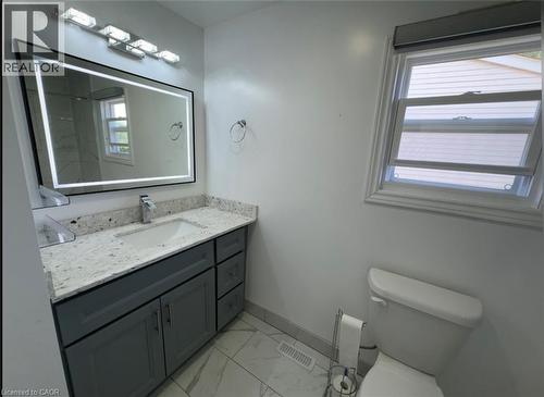 Bathroom vanity featuring gray cabinetry, a light-toned countertop, and an integrated rectangular sink with a chrome faucet - 28 Timberlane Crescent Unit# Upper, Kitchener, ON - Indoor Photo Showing Bathroom
