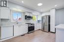 Modern kitchen featuring white shaker-style cabinetry, stainless steel appliances, a white tile backsplash, light-toned wood-finish flooring, and recessed lighting - 100 Lauris Avenue, Cambridge, ON  - Indoor Photo Showing Kitchen With Upgraded Kitchen 
