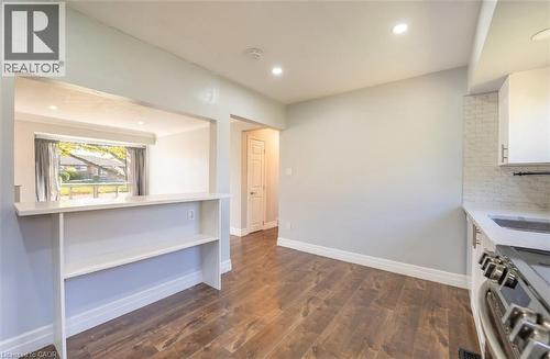 Open-concept kitchen and dining area featuring wood-finish flooring, white cabinetry, a white subway tile backsplash, and recessed lighting - 100 Lauris Avenue, Cambridge, ON - Indoor