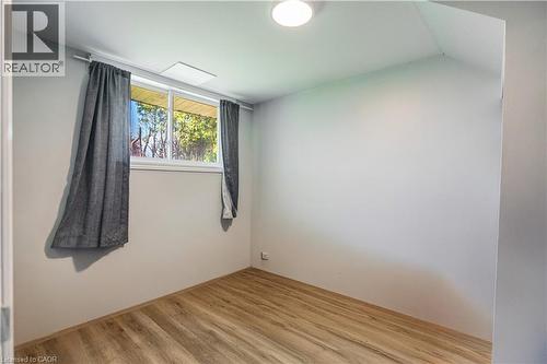 Room featuring wood-finish flooring, a double-paned window, and a flush-mount ceiling light - 100 Lauris Avenue, Cambridge, ON - Indoor Photo Showing Other Room