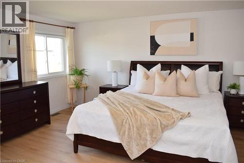 Bedroom featuring light wood-finish flooring, white walls, and a large window - 28 Lemon Grass Street, Kitchener, ON - Indoor Photo Showing Bedroom