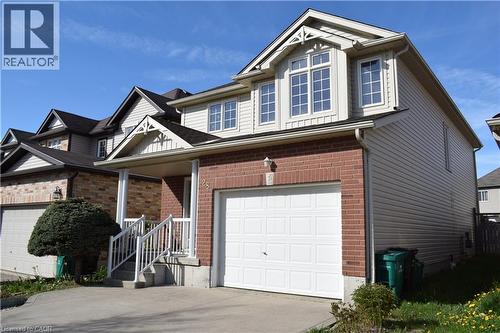 Exterior featuring a brick facade, light-toned siding, and an attached single-car garage - 28 Lemon Grass Street, Kitchener, ON - Outdoor