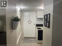 Compact kitchen area featuring a gas range, white cabinetry, and a range hood, complemented by tile flooring - 52 Emerson Street, Hamilton, ON  - Indoor 