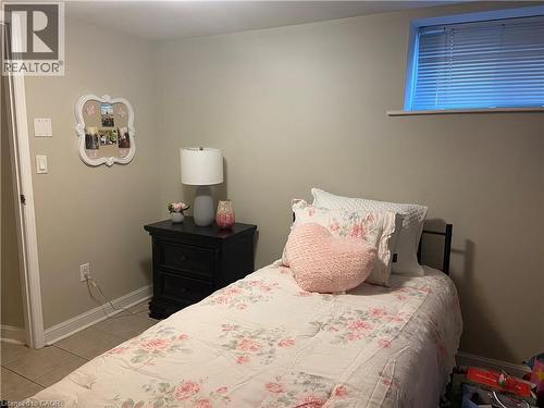 Neutral wall finishes with white trim, light tile flooring, and an elevated window - 52 Emerson Street, Hamilton, ON - Indoor Photo Showing Bedroom