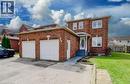 Brick exterior residence featuring a two-car garage with white doors, a concrete driveway, and a well-maintained lawn - 334 Christopher Drive, Cambridge, ON  - Outdoor 