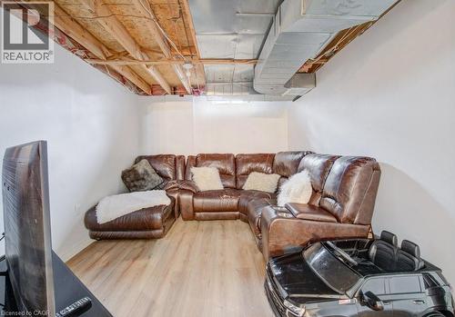 Finished lower level space featuring wood-finish flooring, white painted walls, and exposed ceiling joists with ductwork - 334 Christopher Drive, Cambridge, ON - Indoor