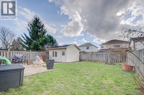 Expansive backyard featuring a green lawn, wood fence perimeter, a detached storage shed, a stone paver patio, and mature tree landscaping - 334 Christopher Drive, Cambridge, ON - Outdoor