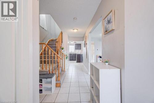 Foyer featuring a carpeted staircase with wood banister, tile flooring, and recessed lighting - 334 Christopher Drive, Cambridge, ON - Indoor Photo Showing Other Room