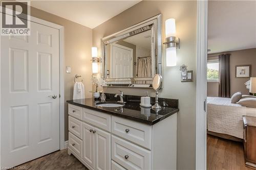Bathroom vanity featuring white cabinetry, dark countertop, and a vessel sink - 643 Artreva Crescent, Burlington, ON - Indoor
