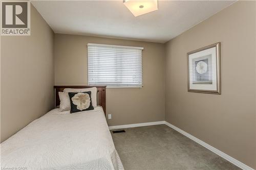 Neutral-toned walls and plush gray carpeting create a versatile interior space - 643 Artreva Crescent, Burlington, ON - Indoor Photo Showing Bedroom