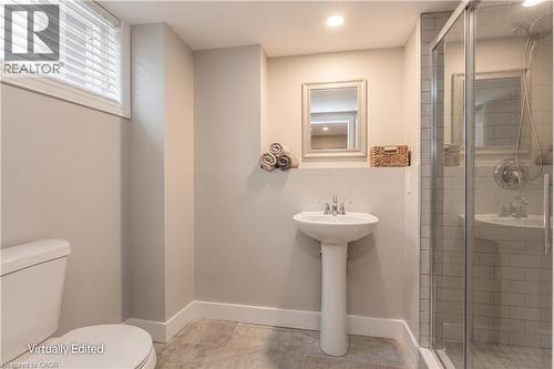 Full bathroom featuring a pedestal sink, framed mirror, and a glass-enclosed shower with subway tile surround - 643 Artreva Crescent, Burlington, ON - Indoor Photo Showing Bathroom