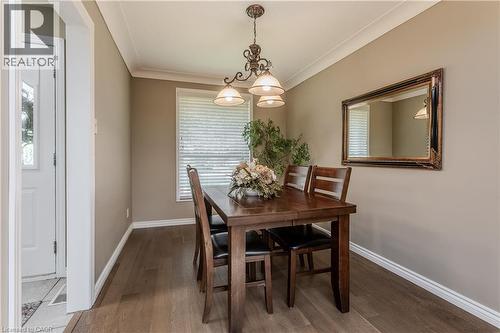 Dining area featuring wood-finish flooring, a window with blinds, and crown molding - 643 Artreva Crescent, Burlington, ON - Indoor Photo Showing Dining Room