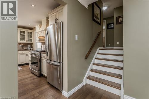 Kitchen with cream cabinetry, stainless steel appliances, and wood-finish flooring - 643 Artreva Crescent, Burlington, ON - Indoor