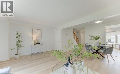 Living area with light-toned wood-finish flooring, white walls, and recessed lighting - 603 Pinerow Crescent Unit# B, Waterloo, ON 