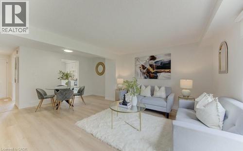 Open-concept living area featuring light wood-finish flooring, recessed lighting, and crown molding - 603 Pinerow Crescent Unit# B, Waterloo, ON 