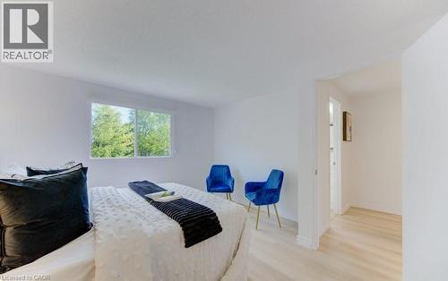 Light-filled room featuring a broad window, white walls, and wood-finish flooring - 603 Pinerow Crescent Unit# B, Waterloo, ON 