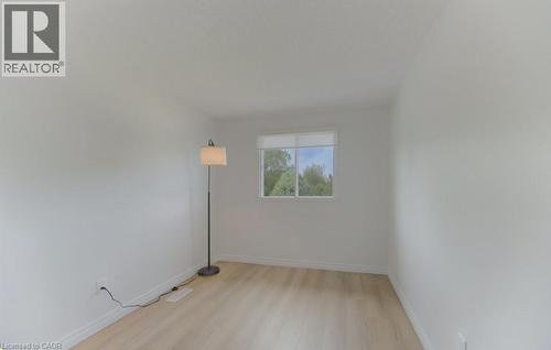 Room featuring light wood-finish flooring, white baseboards, and a single window with white trim - 603 Pinerow Crescent Unit# B, Waterloo, ON 